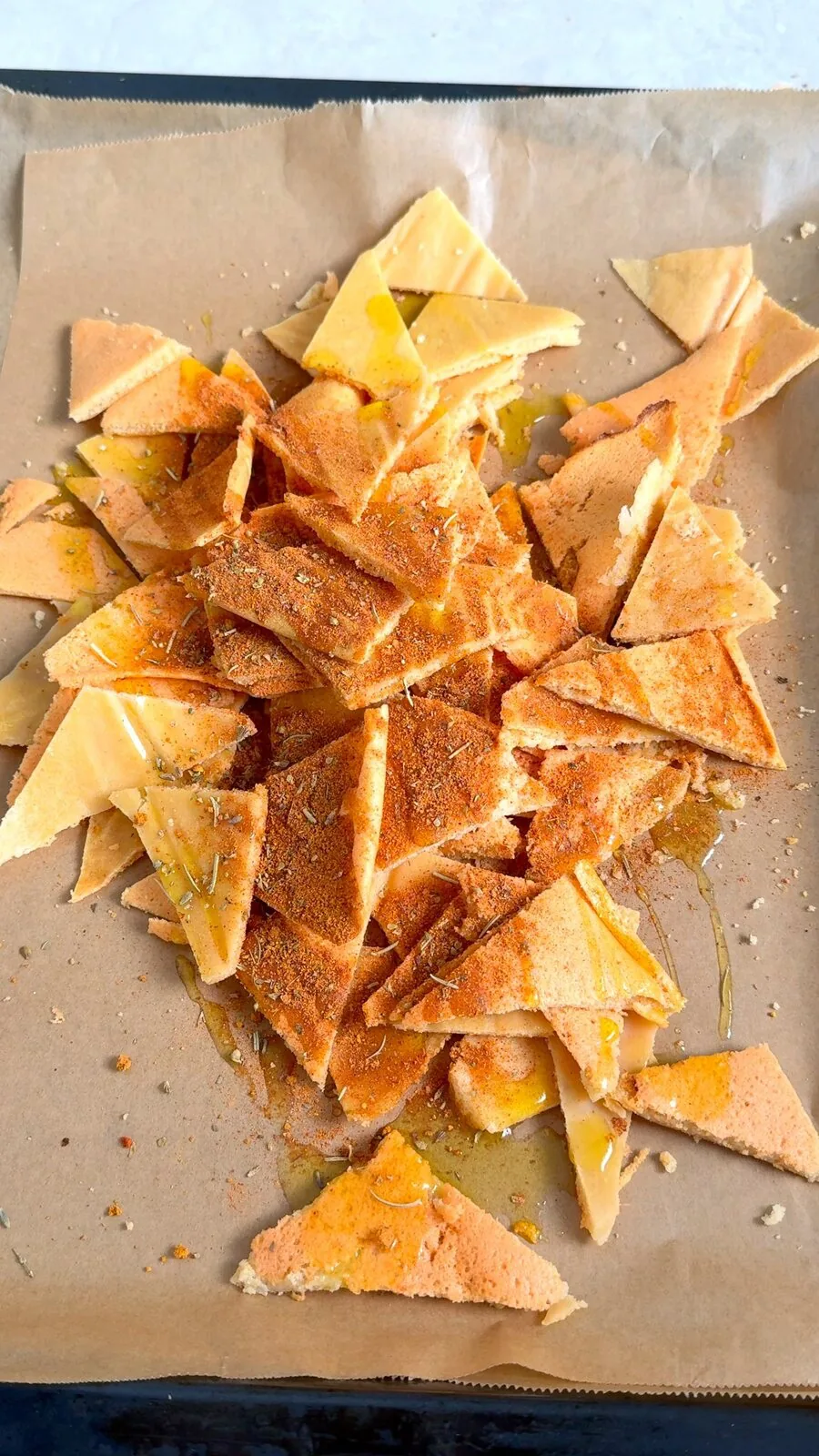 Lentil chip triangles seasoned with paprika and herbs before the second bake