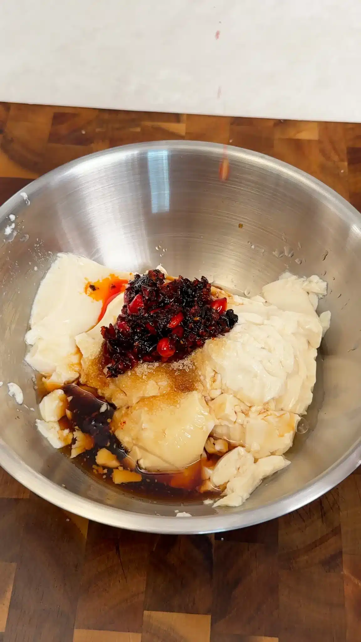 Silken tofu, chili crisp and sauce seasonings in a mixing bowl