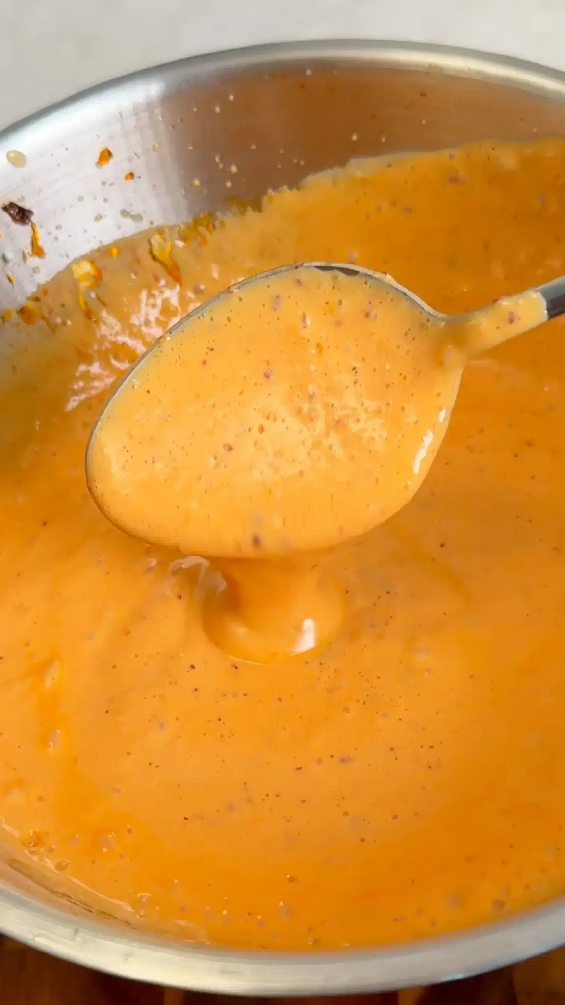 Smooth orange silken tofu sauce coating a spoon