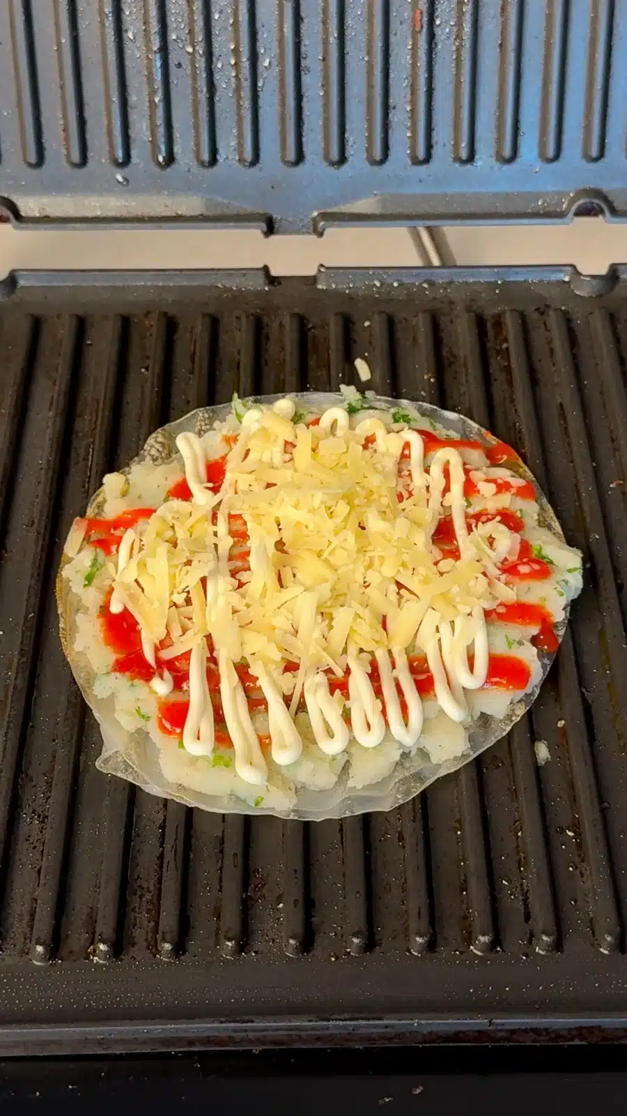 Rice paper topped with mashed potato, sriracha, vegan mayo and grated vegan cheese
