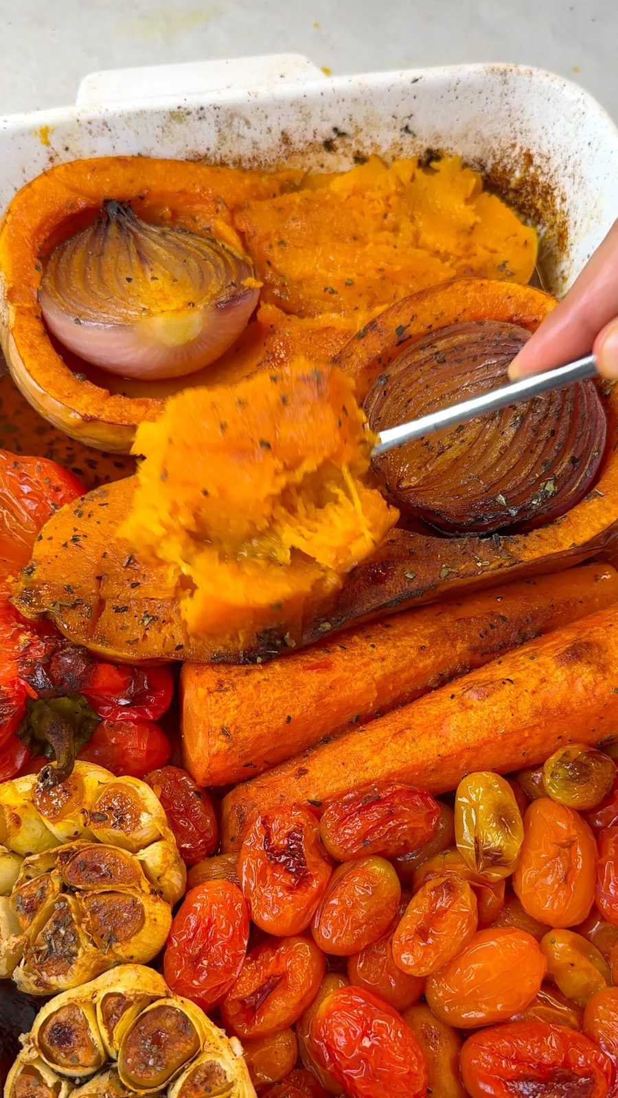 Spoon scooping soft roasted butternut squash flesh out of its skin