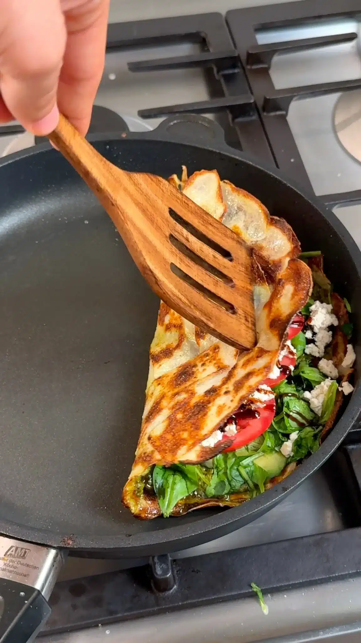 Golden potato wrap being folded over its filling with a spatula