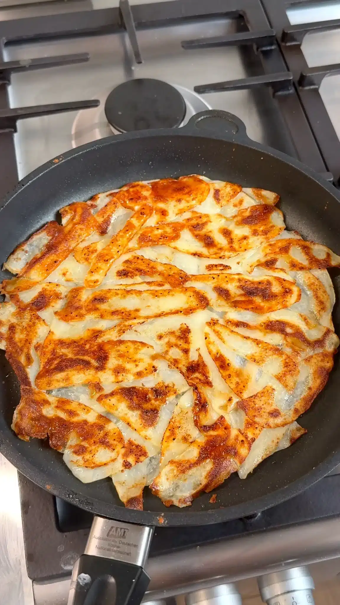 Golden skillet potato wrap base after flipping in the frying pan