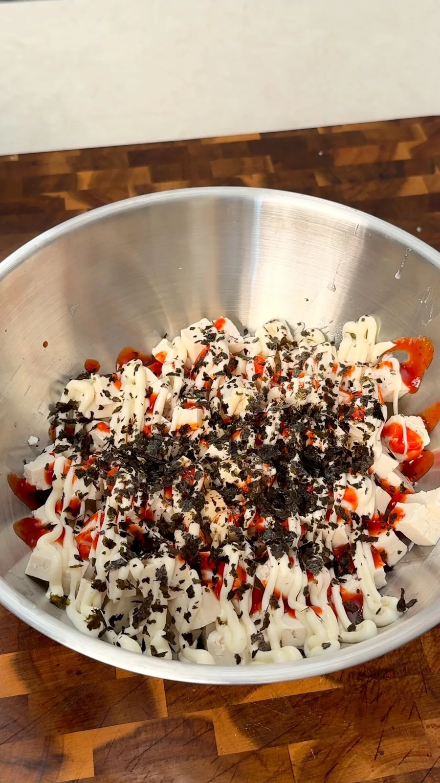 Cubed tofu with vegan mayo, sriracha and nori flakes in a bowl