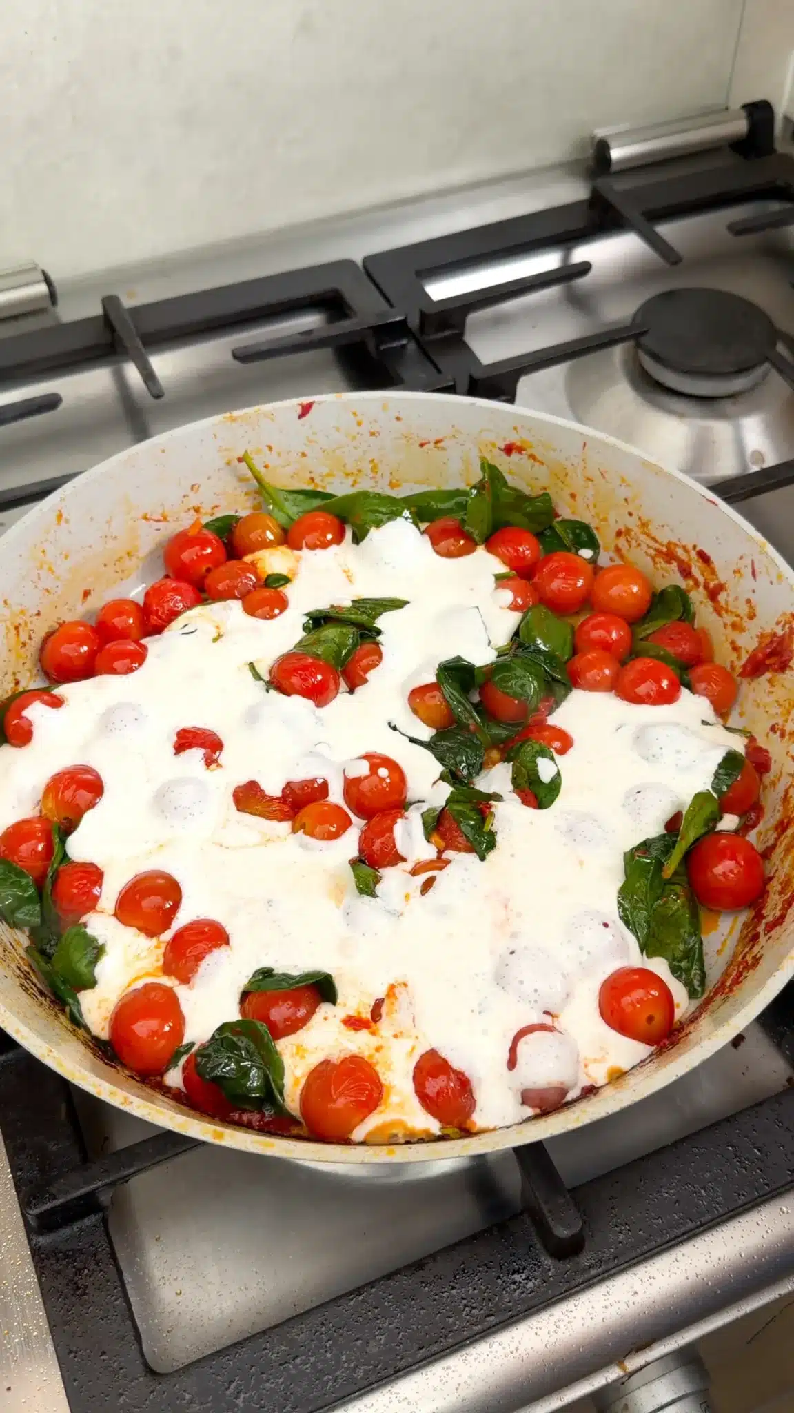 Blended vegan cream and silken tofu poured over tomatoes and spinach