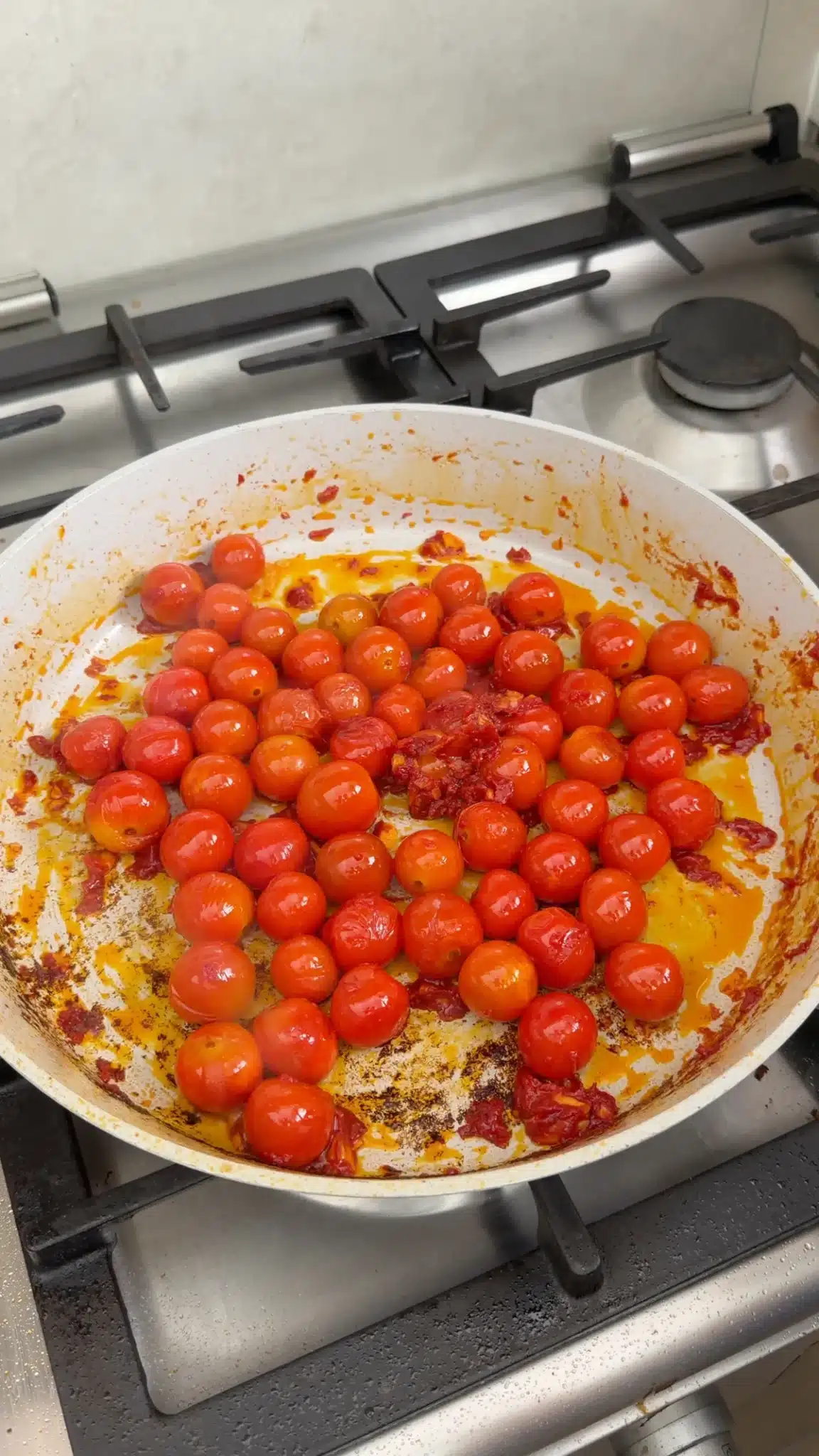 Cherry tomatoes and tomato paste cooking in olive oil