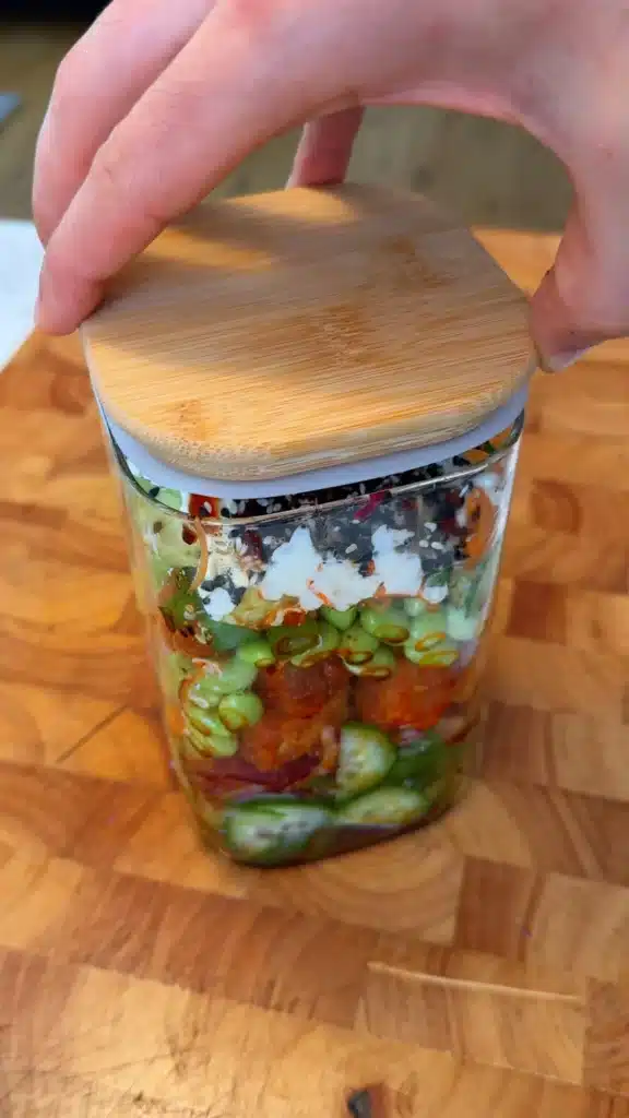 Covered jar of creamy cucumber salad ready to mix