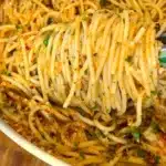 Garlic butter pasta with basil and vegan Parmesan in a serving bowl