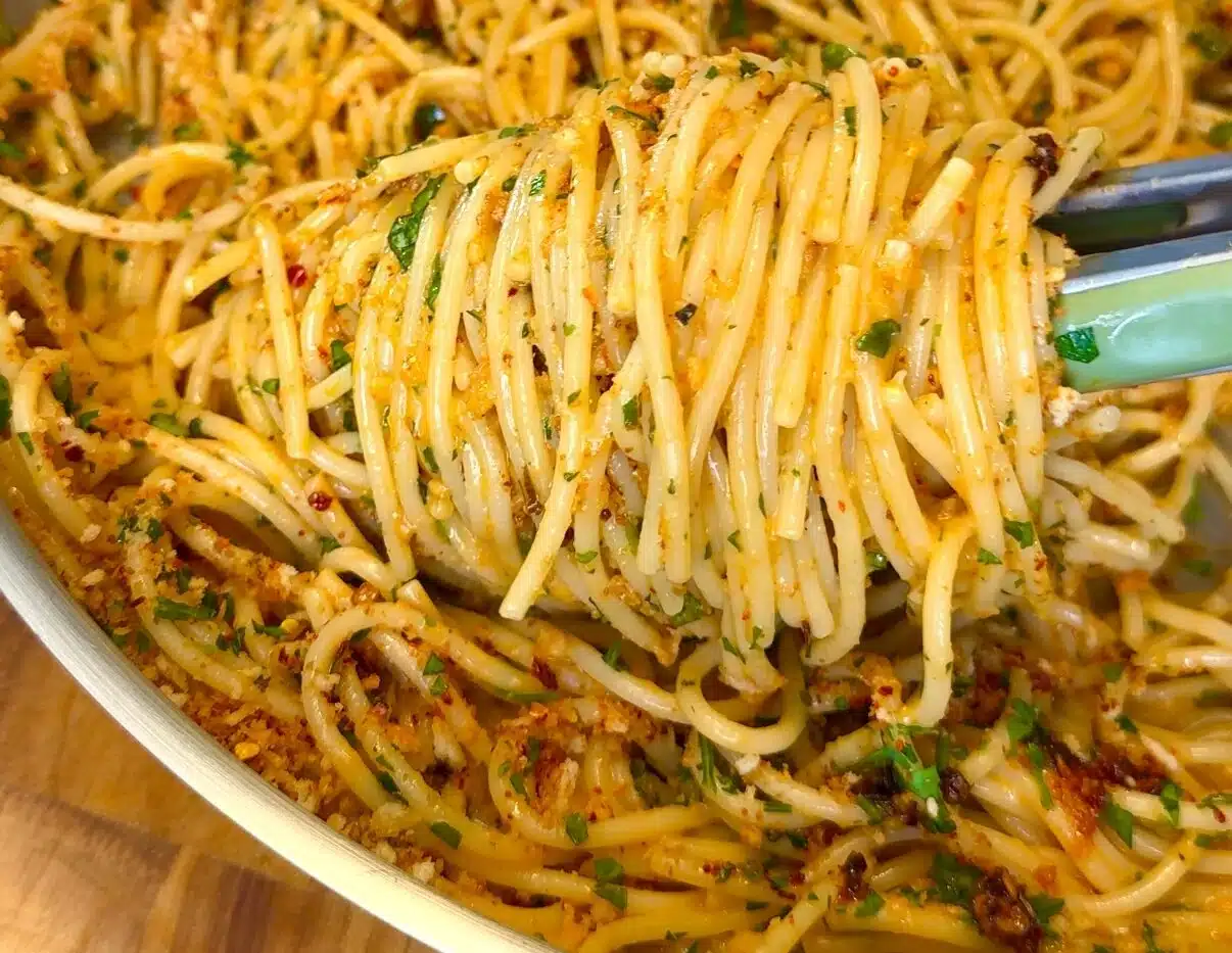 Garlic butter pasta with basil and vegan Parmesan in a serving bowl