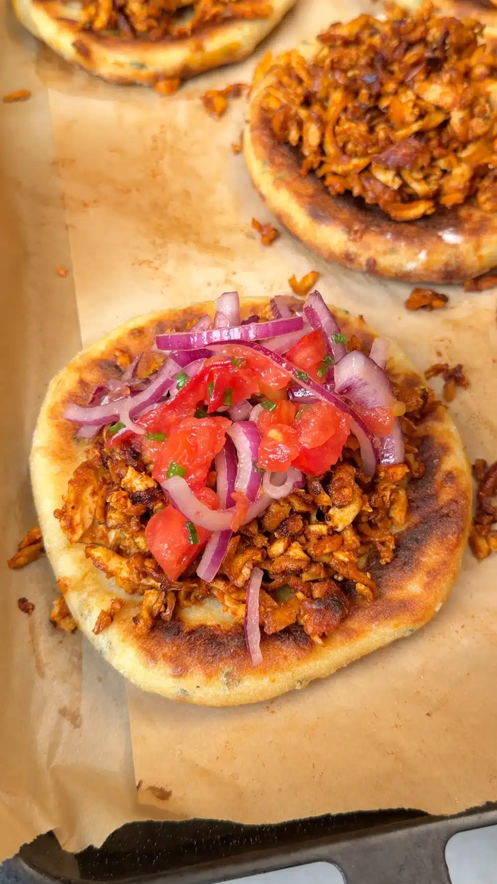 Baked potato flatbread topped with glazed tofu and tomato-onion salad