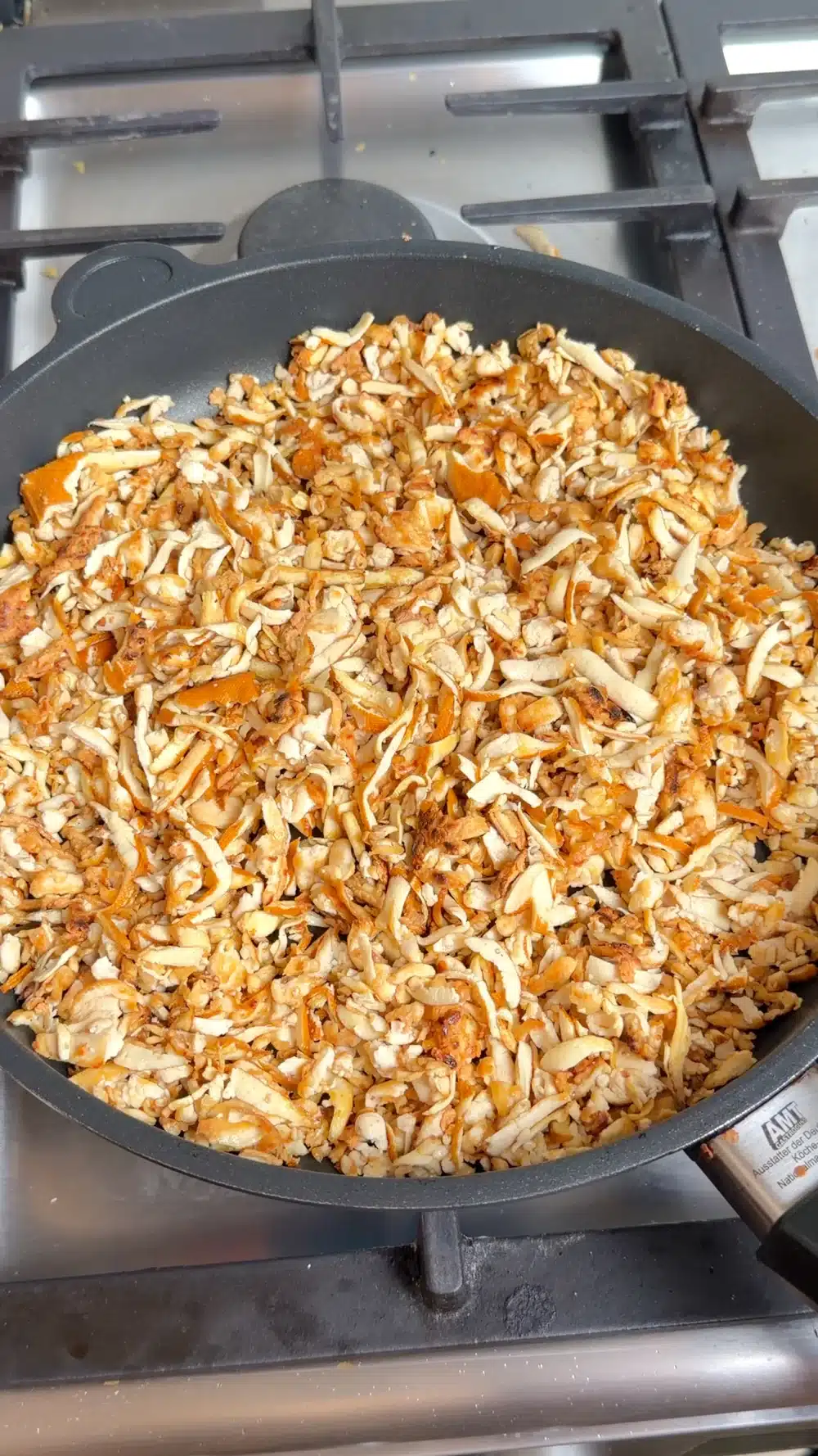 Coarsely grated tofu browning in a frying pan
