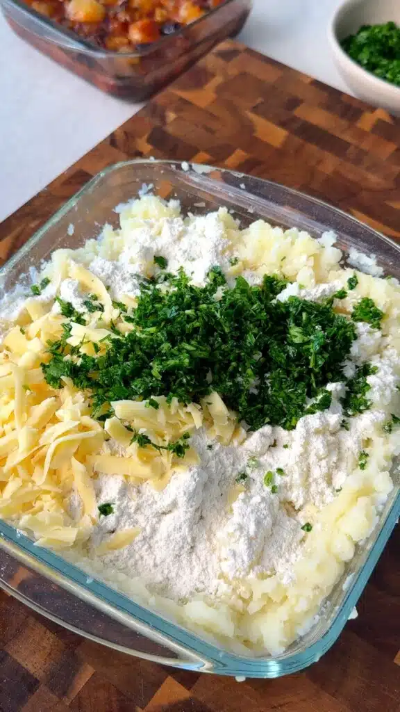 Flour, vegan cheese and herbs added to mashed potatoes
