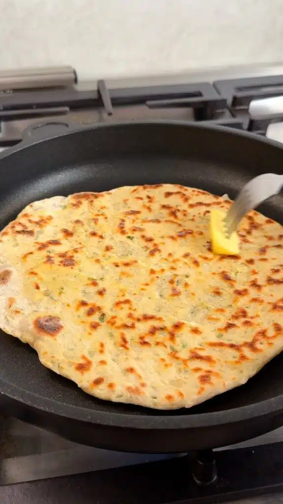 Golden potato flatbread cooking in a skillet