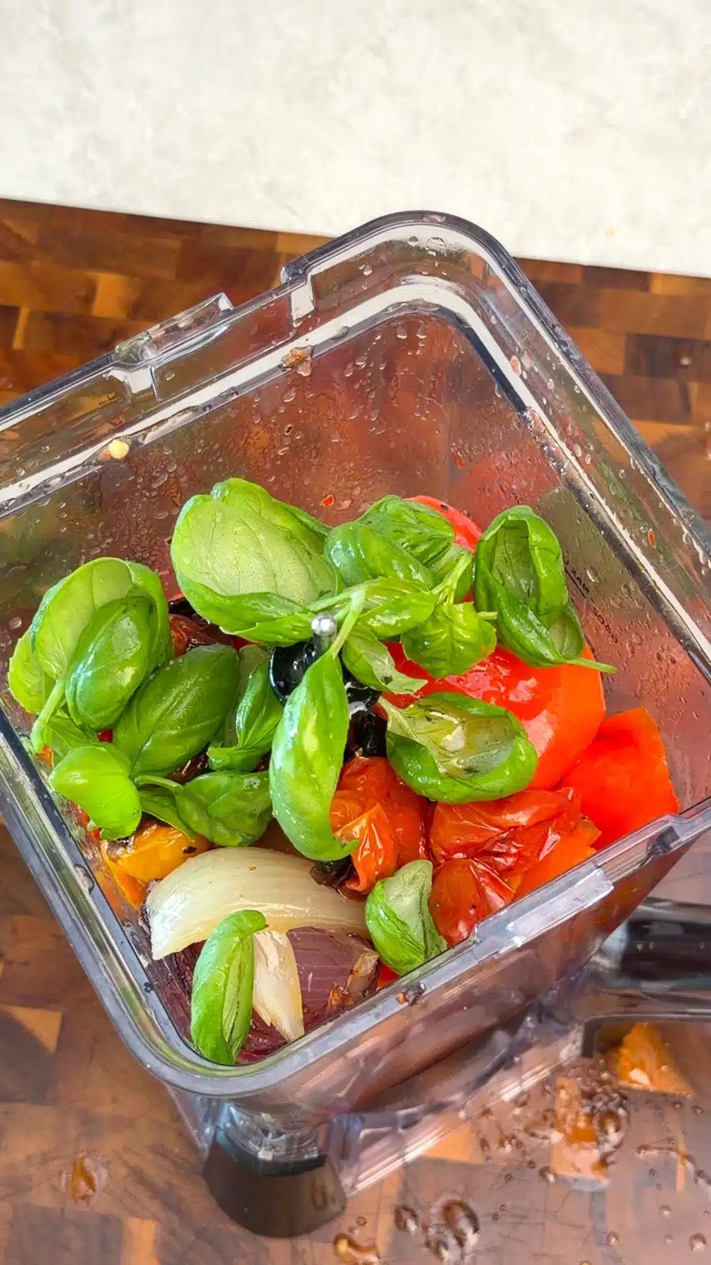 Roasted vegetables and fresh basil in a blender