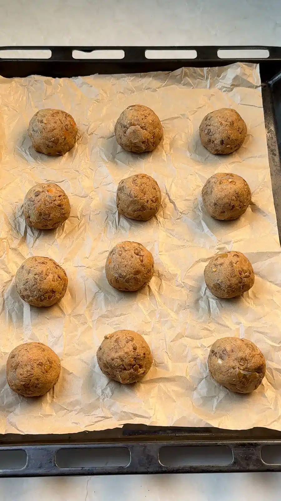 Shaped lentil meatballs on a lined baking tray