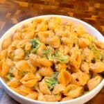 Vegan mac and cheese with broccoli and pasta shells in a white bowl